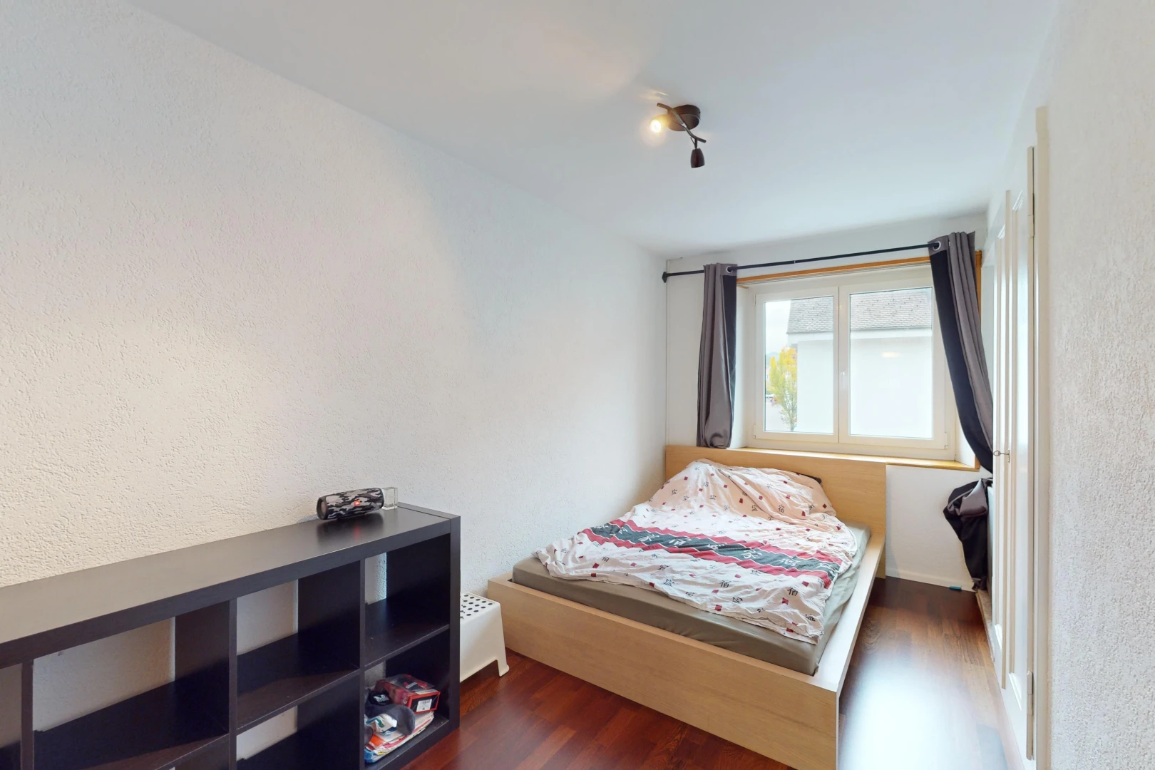 chambre avec lumière naturelle et plancher de bois