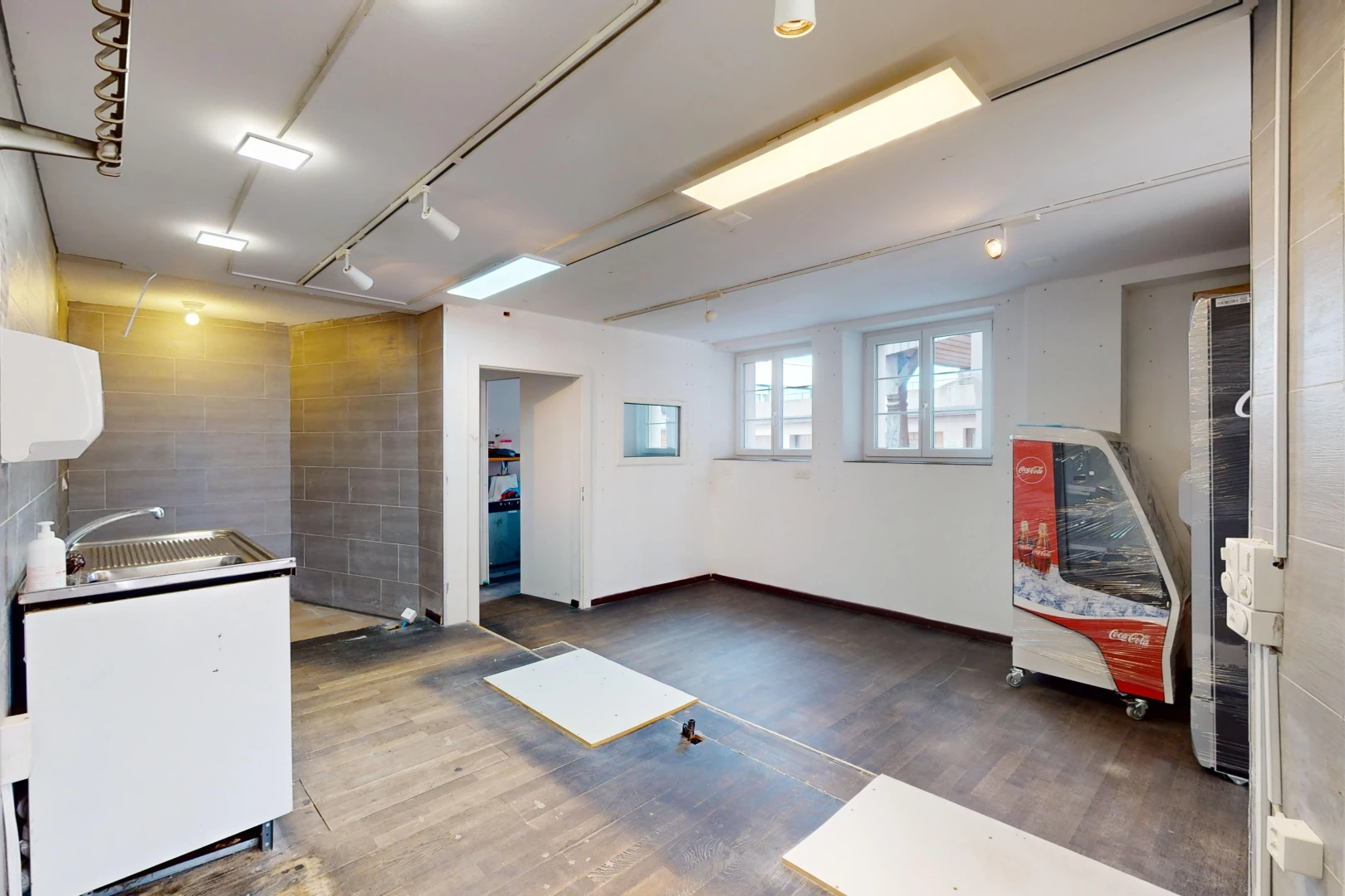 cuisine avec lumière naturelle, vasque, plancher de bois, et meubles blancs