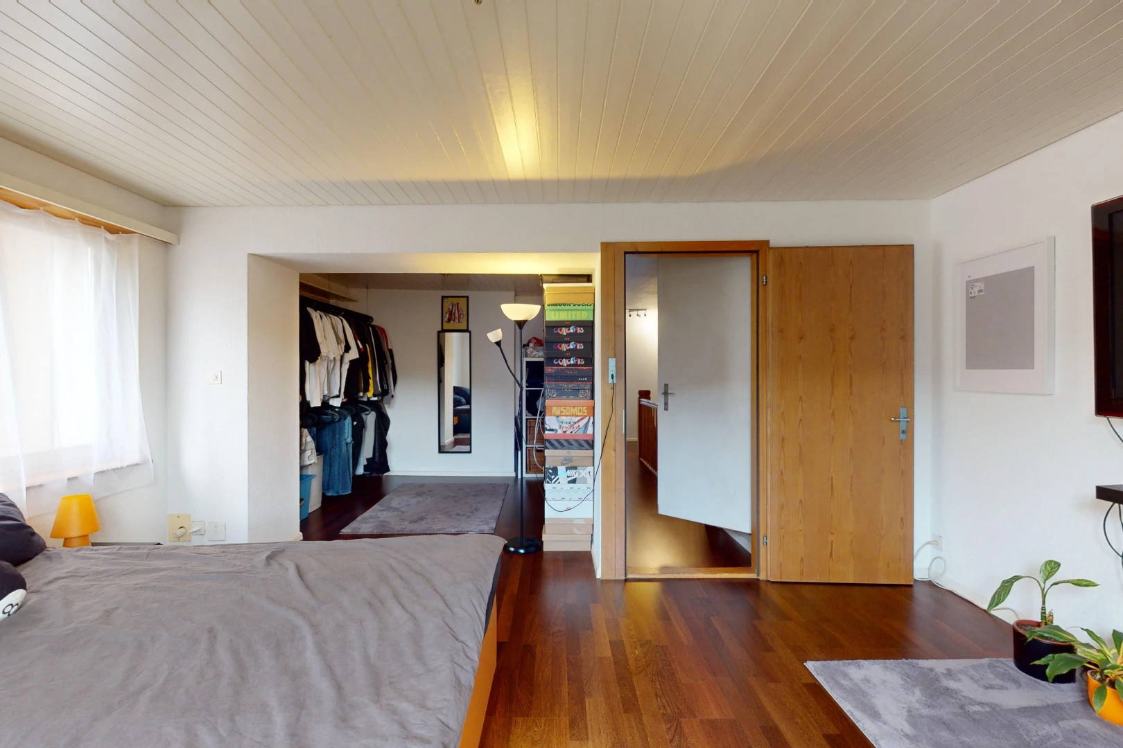 chambre avec placard, lumière naturelle, et plancher de bois