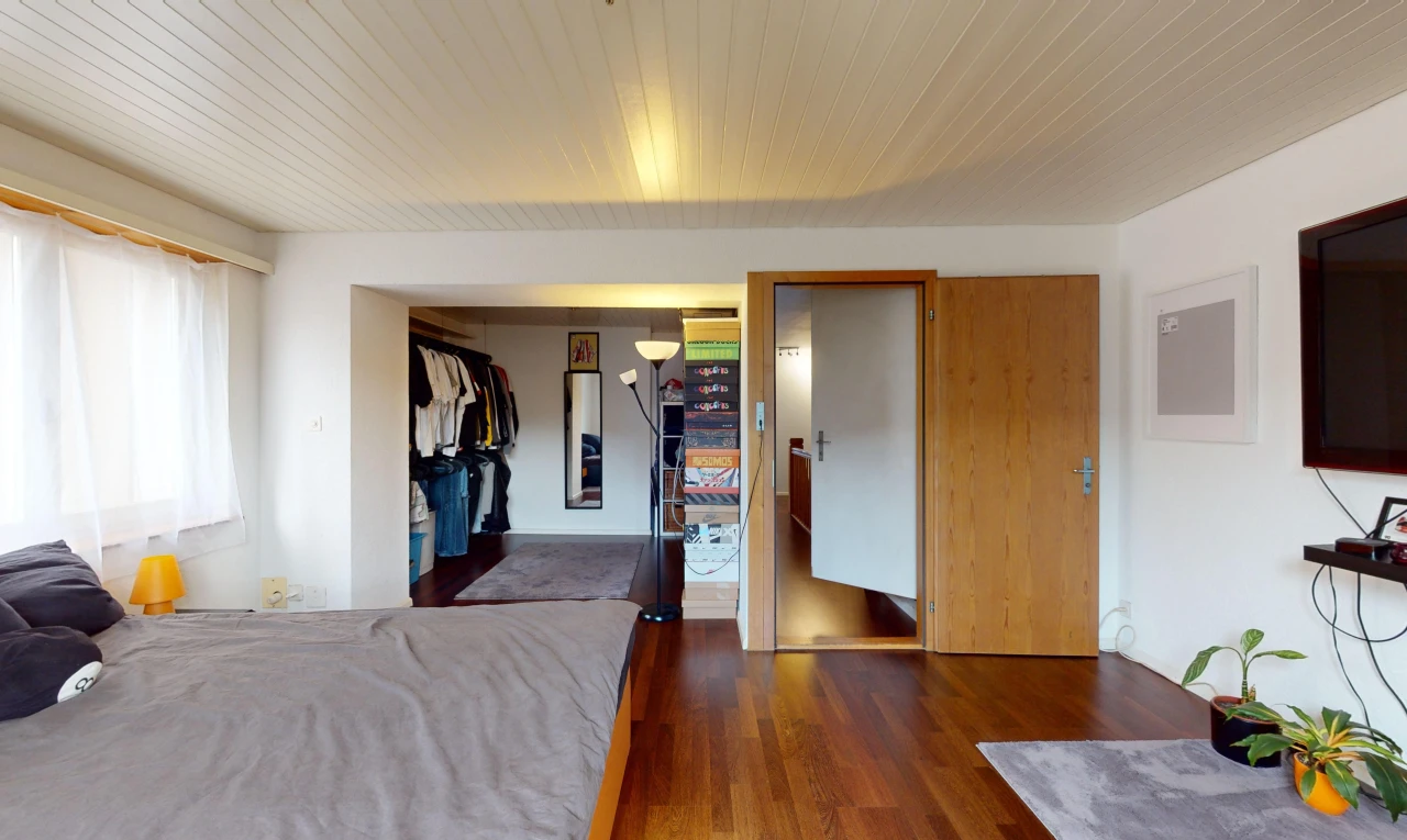 chambre avec placard, lumière naturelle, et plancher de bois