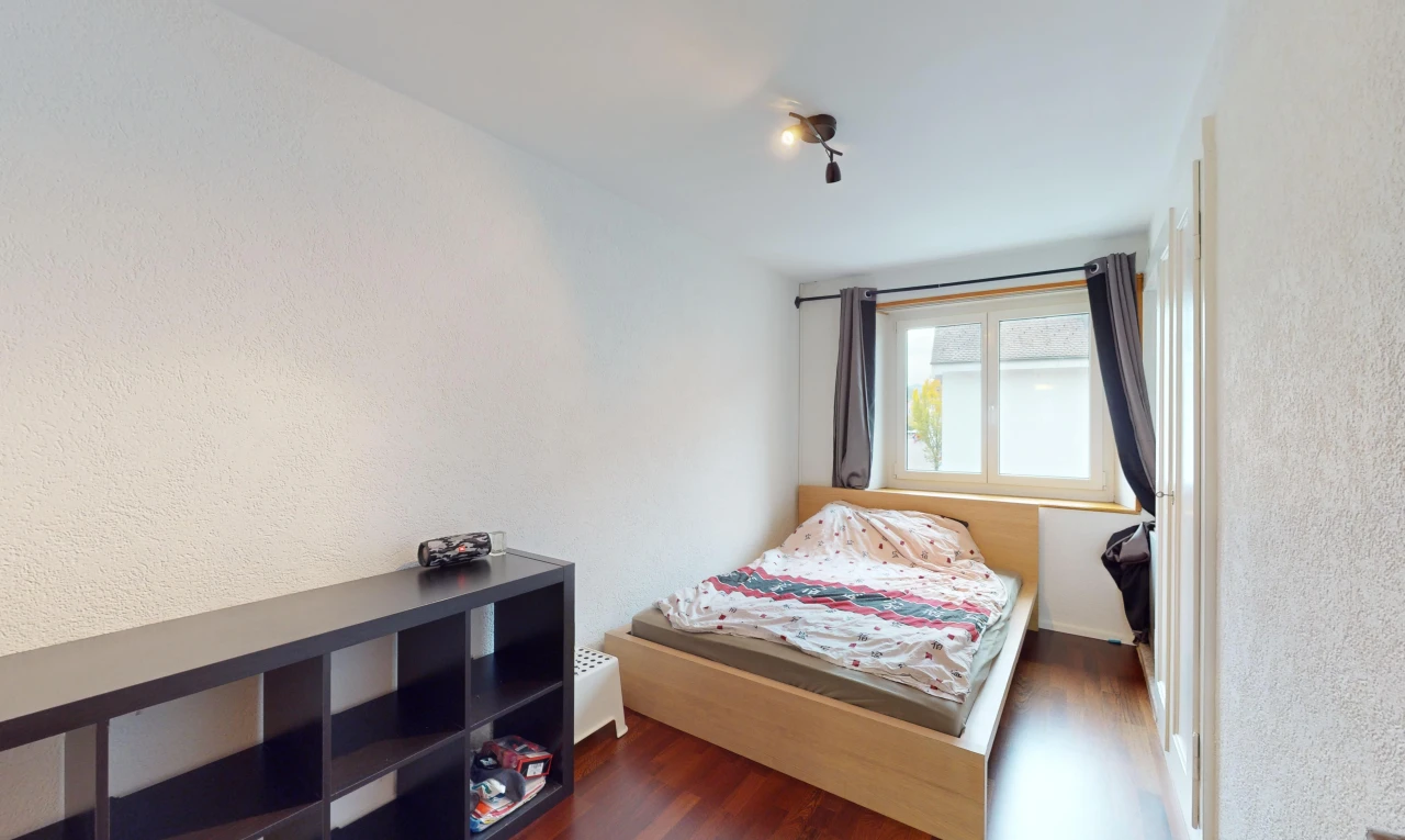 chambre avec lumière naturelle et plancher de bois