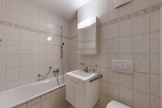 salle de bains avec mur en carrelage, tile wall, lavabo (ou coiffeuse selon le contexte), miroir, et salle de bain complète