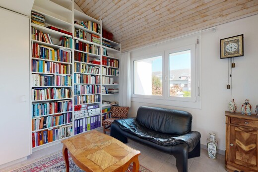 living room with a vaulted wood ceiling, bookshelves, and built in features