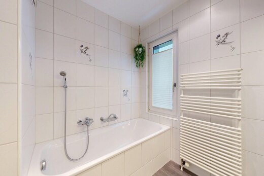 salle de bains avec radiateur, chauffe-serviettes, bain, mur en carrelage, et tile wall