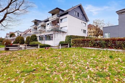 view of property featuring a balcony and a lawn