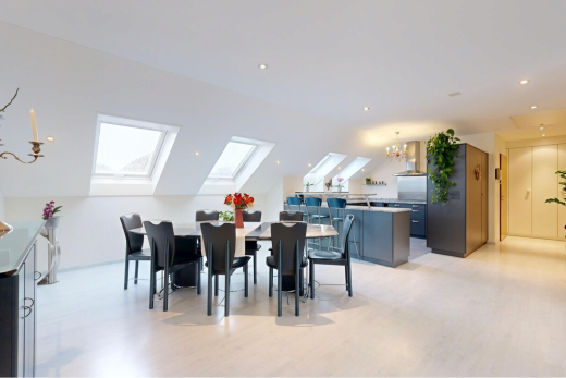 dining area with a chandelier, light wood finished floors, vaulted ceiling, and a skylight