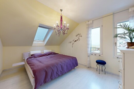 room / bedroom with wood finished floors, vaulted ceiling, suspended lighting, multiple windows, and a skylight