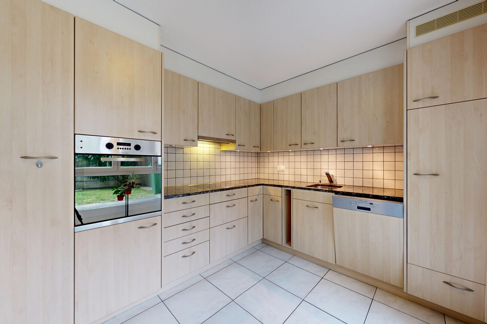 cuisine avec armoires marron clair, light brown cabinets, dark countertops, four, et light floor