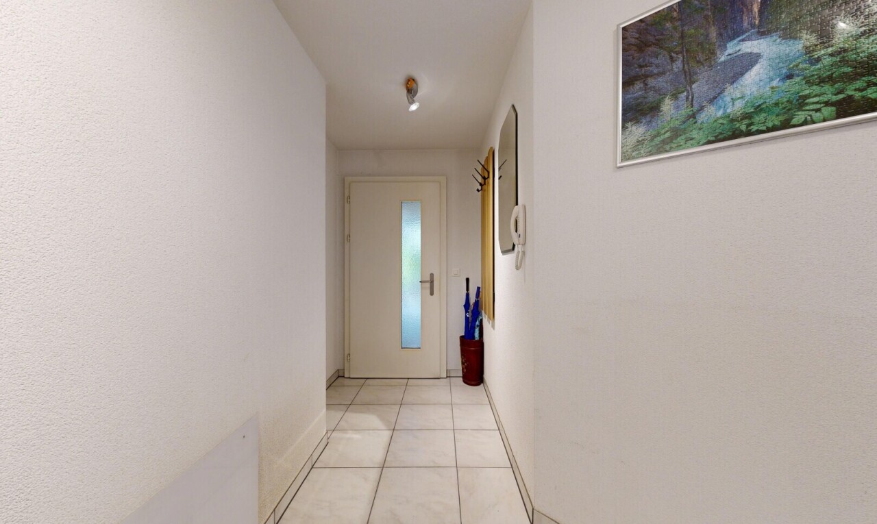 couloir avec light floor, inside property, sol en carrelage, tile floor, et plinthes murales