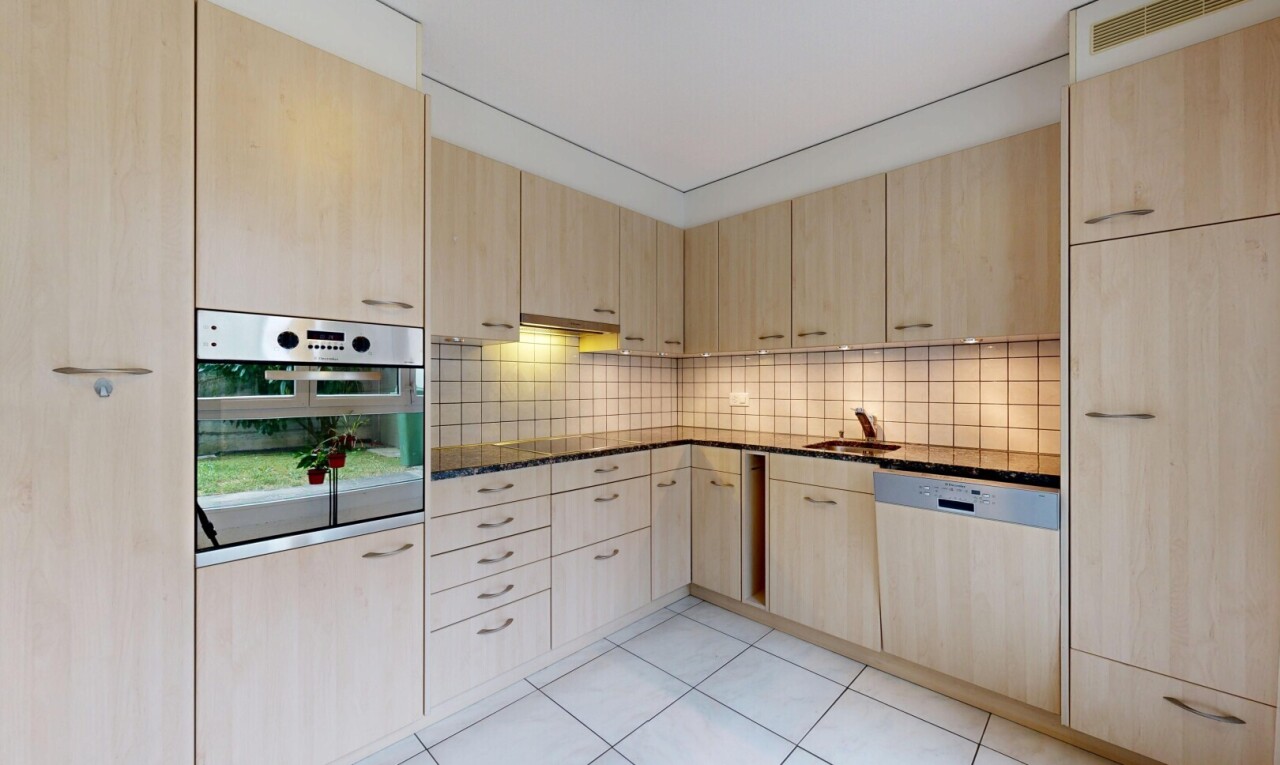 cuisine avec armoires marron clair, light brown cabinets, dark countertops, four, et light floor
