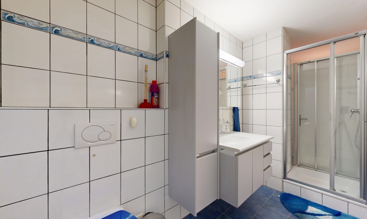 salle de bains avec mur en carrelage, tile wall, douche, salle de bain complète, et lavabo (ou coiffeuse selon le contexte)