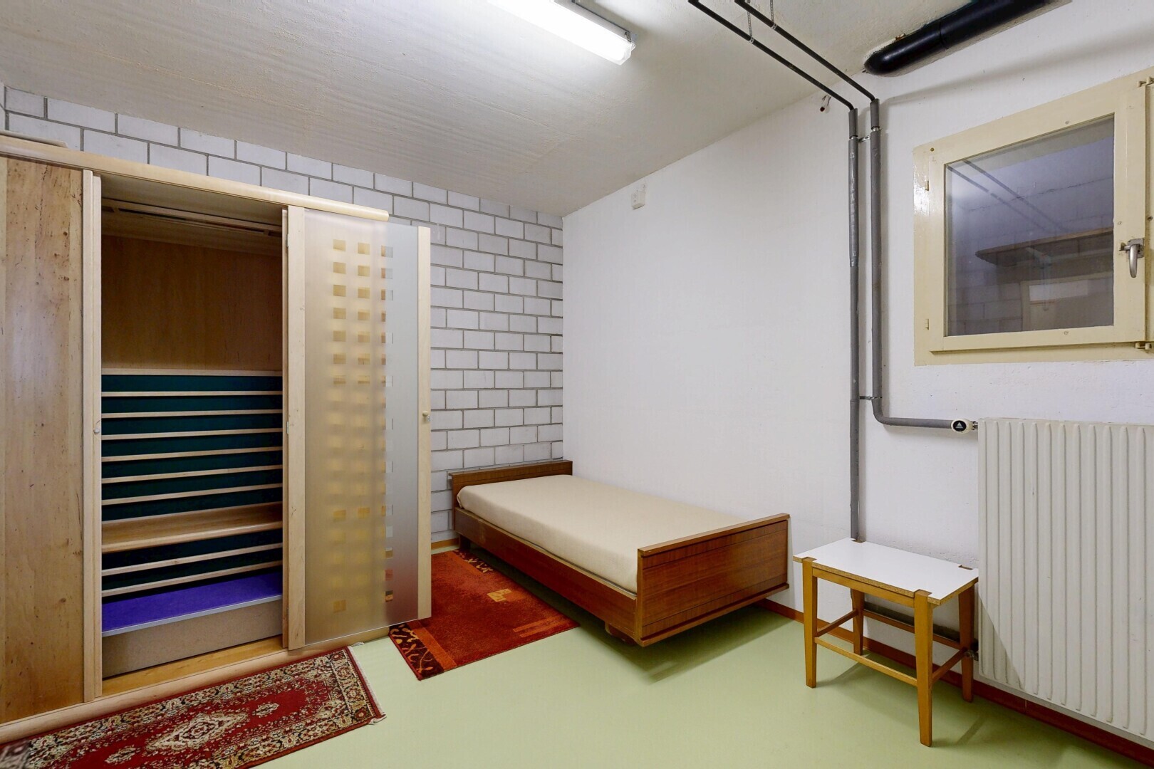 room with radiator heating unit and concrete floors