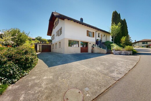 view of property featuring stucco siding, driveway, and a garage