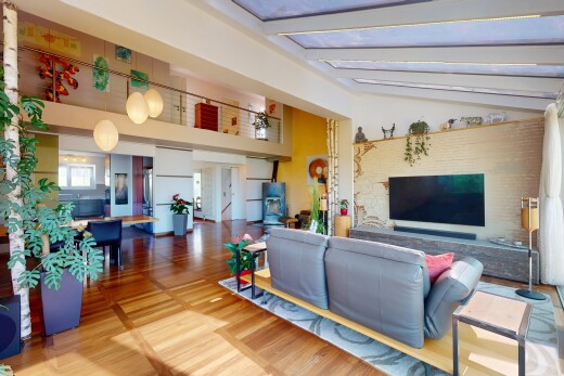 salon / salle à manger avec cloison sèche, lumière naturelle, plafond voûté, sol en finition bois, et télévision