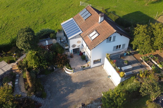 façade avec aire de stationnement et panneaux solaires