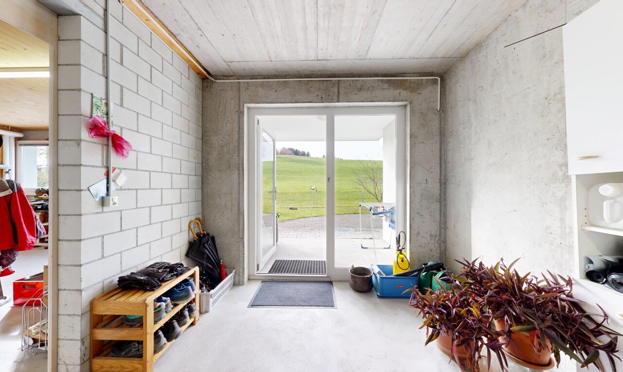 salon avec mur en béton, concrete wall, lumière naturelle, natural light, et inside property
