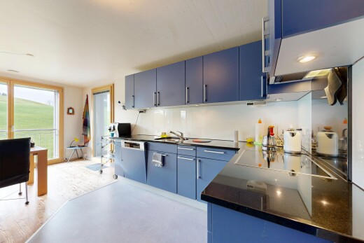 küche mit blaue schränke, inside property, herd, natural light, und natürliches licht