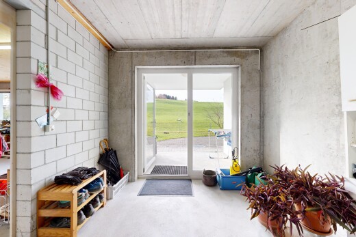 salon avec mur en béton, concrete wall, lumière naturelle, natural light, et inside property