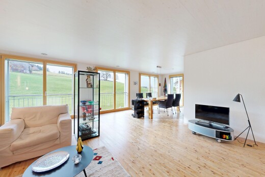 wohn- / esszimmer mit holzfußboden, wood finish floor, bürobereich, fernseher, und natürliches licht