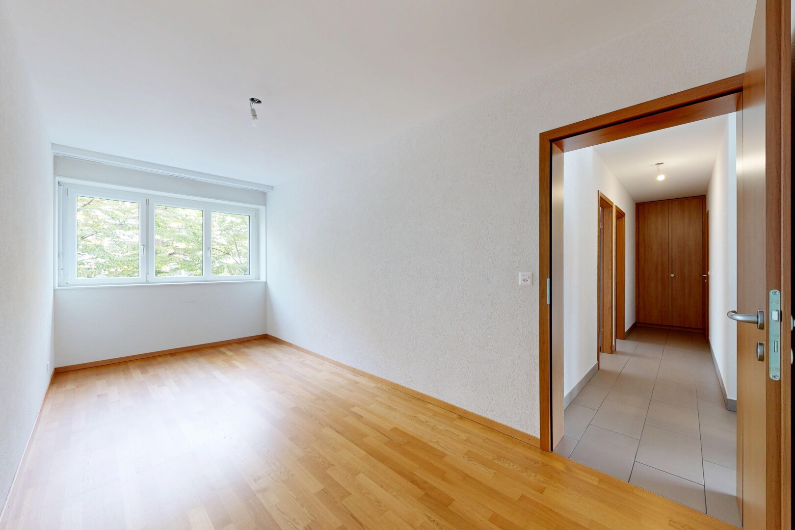 pièce vide avec inside property, wood finish floor, sol en finition bois, natural light, et lumière naturelle