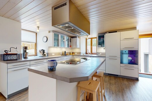 cuisine avec armoires blanches, natural light, lumière naturelle, hotte, et plans de travail