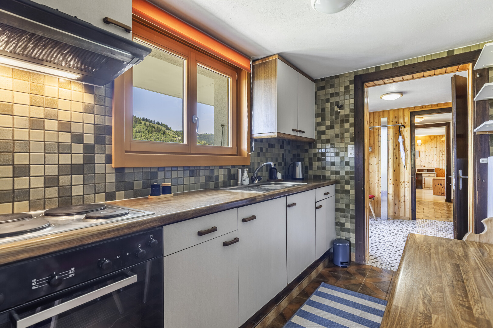 cuisine avec four, dark floor, hotte, white cabinets, et armoires blanches