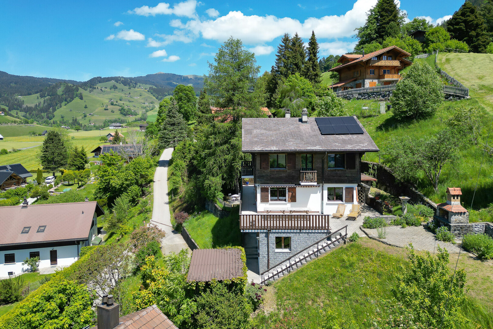 façade avec balcon, panneaux solaires, day time, property visible, et woods view