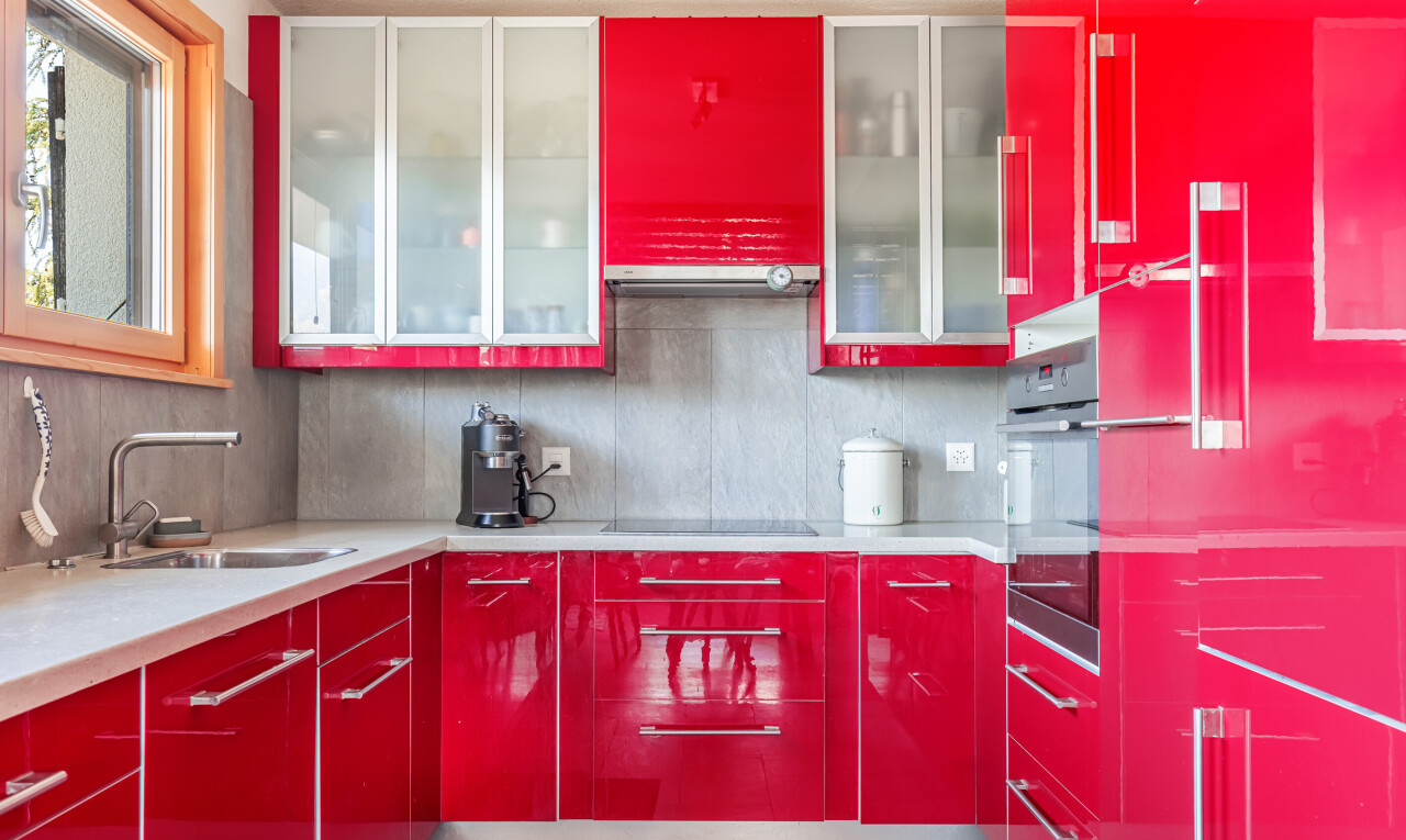 cuisine avec red cabinets, armoires rouges, four, flat panel cabinets, et armoires à panneau plat