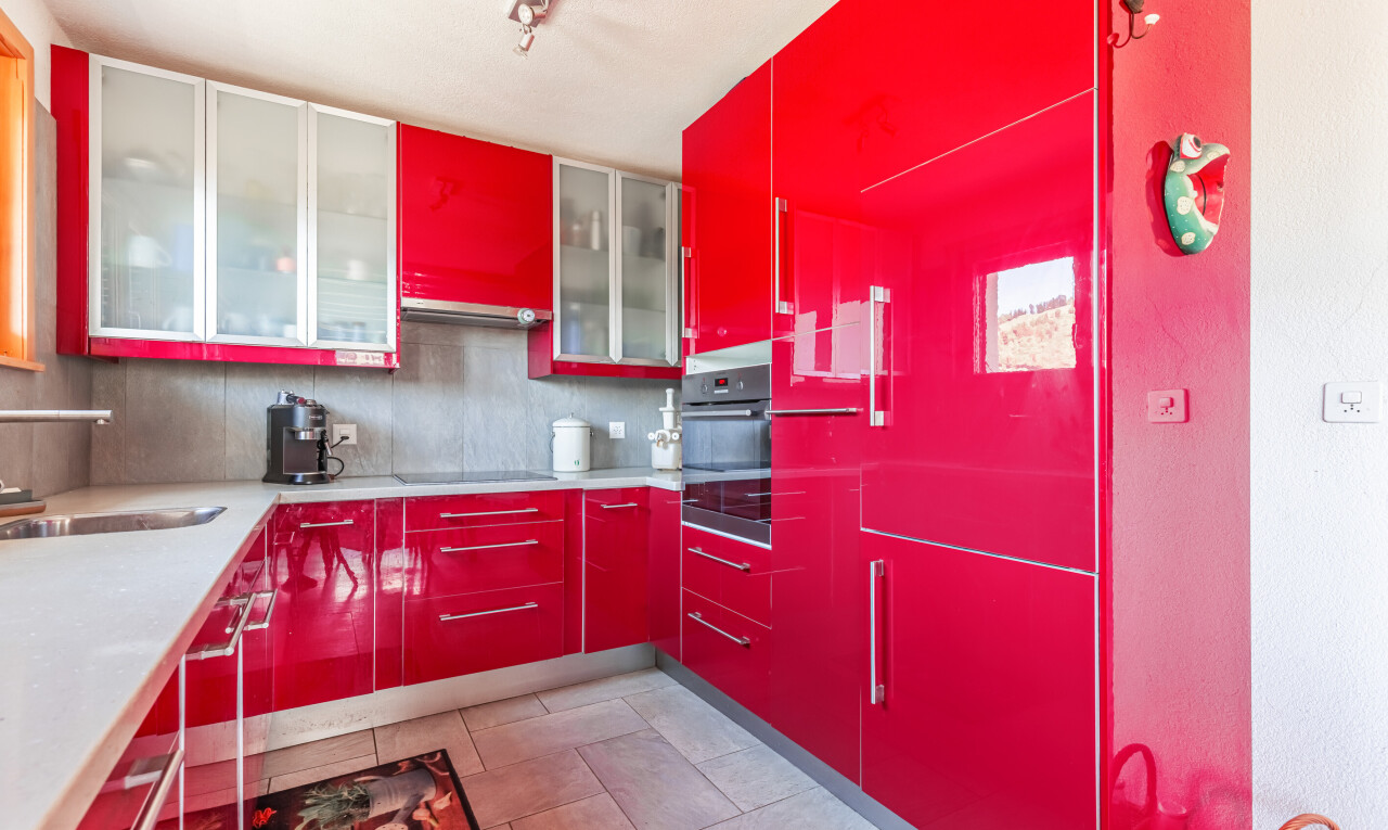 cuisine avec armoires rouges, red cabinets, light floor, four, et évier