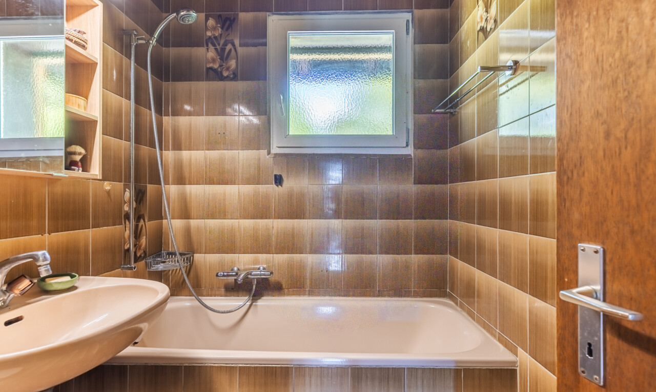 salle de bains avec douche-bain combinés, salle de bain complète, miroir, inside property, et évier