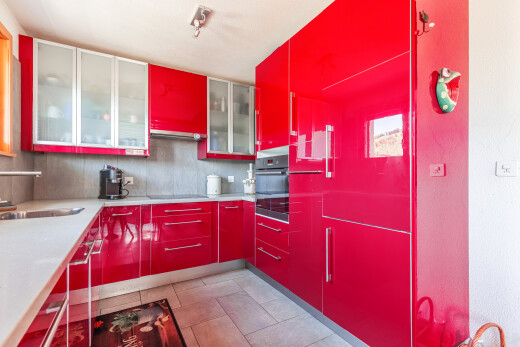 cuisine avec armoires rouges, red cabinets, light floor, four, et évier