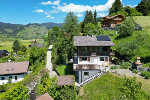 façade avec balcon, panneaux solaires, day time, property visible, et woods view