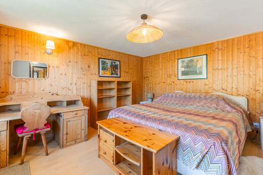 chambre avec sol en finition bois, wood finish floor, light floor, inside property, et mur en bois