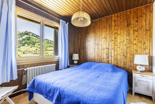 chambre avec inside property, wood wall, mur en bois, natural light, et lumière naturelle