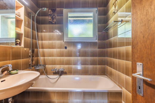 salle de bains avec douche-bain combinés, salle de bain complète, miroir, inside property, et évier