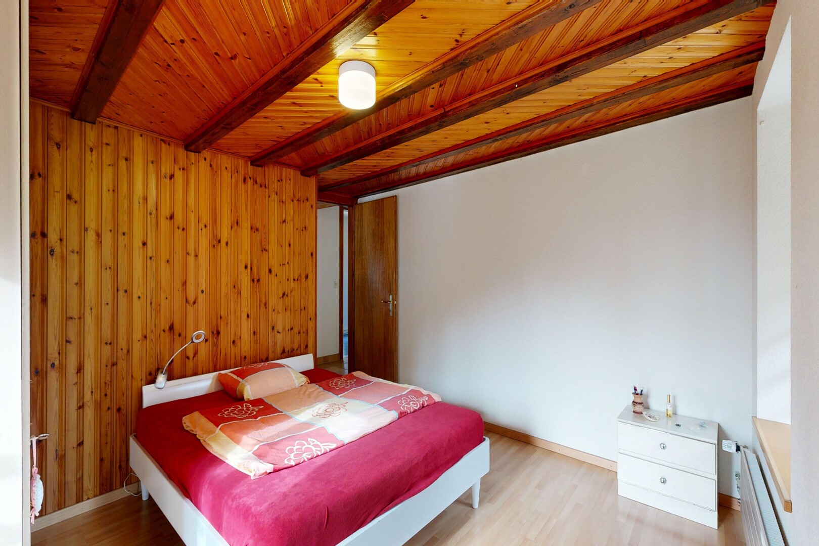 zimmer / schlafzimmer mit holzfußboden, wood finish floor, inside property, holzwand, und wood wall