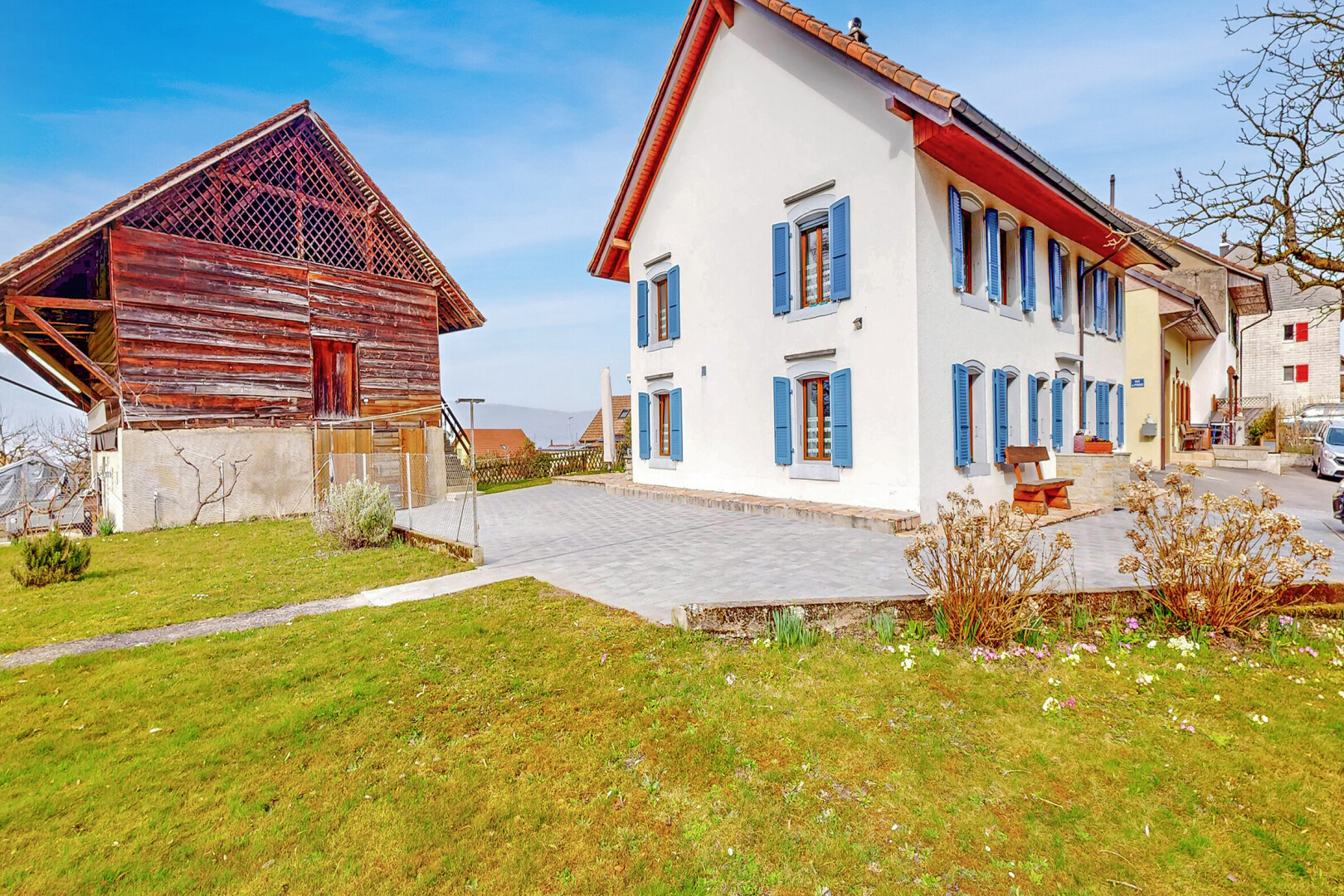 außenansicht mit terrasse, property visible, rasen, stuckverkleidung, und day time
