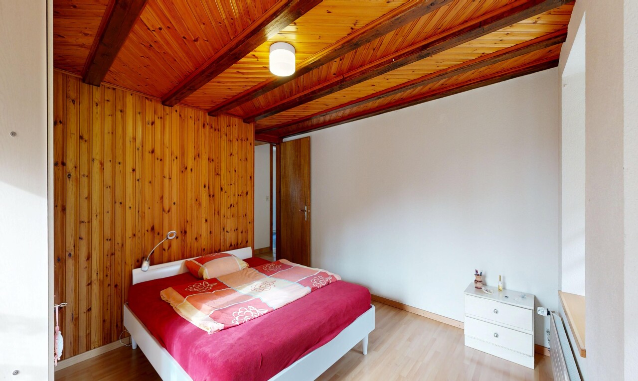 zimmer / schlafzimmer mit holzfußboden, wood finish floor, inside property, holzwand, und wood wall