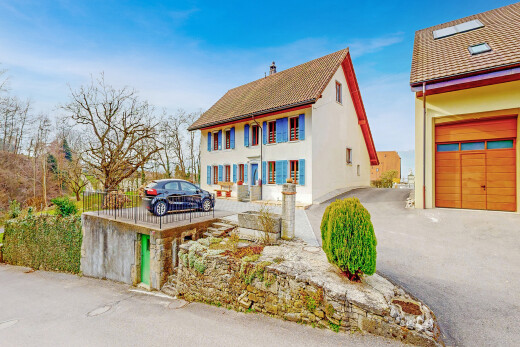 façade avec property visible, day time, garage, bardage en stuc, et allée