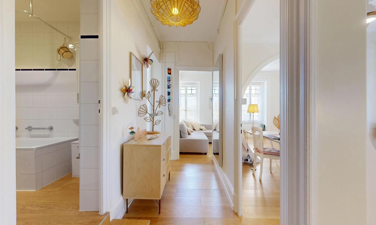 couloir avec wood finish floor, sol en finition bois, light floor, inside property, et éclairage suspendu