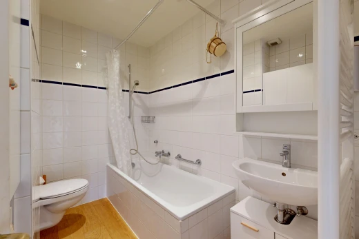 salle de bains avec miroir, mur en carrelage, tile wall, douche-bain combinés, et toilette