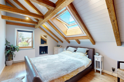 zimmer / schlafzimmer mit balkendecke, parkettboden, natürliches licht, und kühler