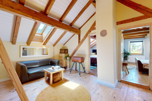 wohnzimmer mit natürliches licht, balkendecke, parkettboden, dachfenster, und dachschräge