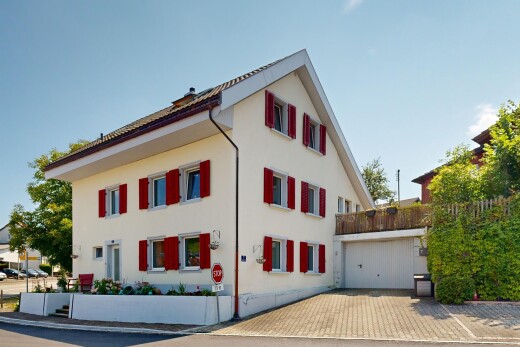 außenansicht mit property visible, day time, auffahrt, garage angeschlossen, und stuckverkleidung