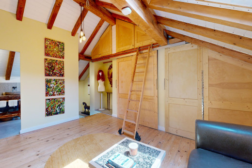 wohnzimmer mit balkendecke, parkettboden, und dachschräge