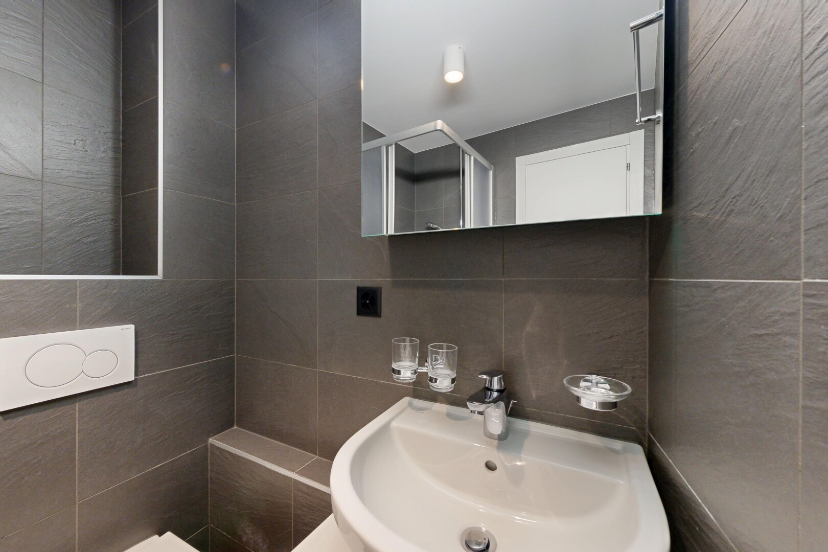 salle de bains avec tile wall, mur en carrelage, miroir, évier, et inside property