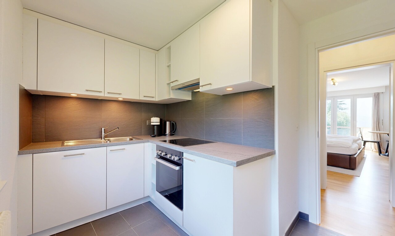 cuisine avec backsplash, dosseret, armoires blanches, four, et natural light