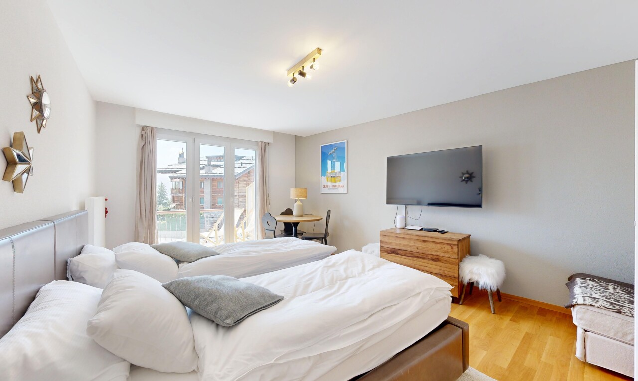 chambre avec télévision, lumière naturelle, natural light, inside property, et sol en finition bois