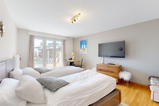 zimmer / schlafzimmer mit fernseher, natürliches licht, natural light, inside property, und holzfußboden