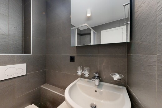 salle de bains avec tile wall, mur en carrelage, miroir, évier, et inside property